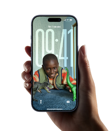 Uma mão segura um iPhone que mostra o novo design em Liquid Glass, que faz as horas se adaptarem dinamicamente à imagem da Tela Bloqueada