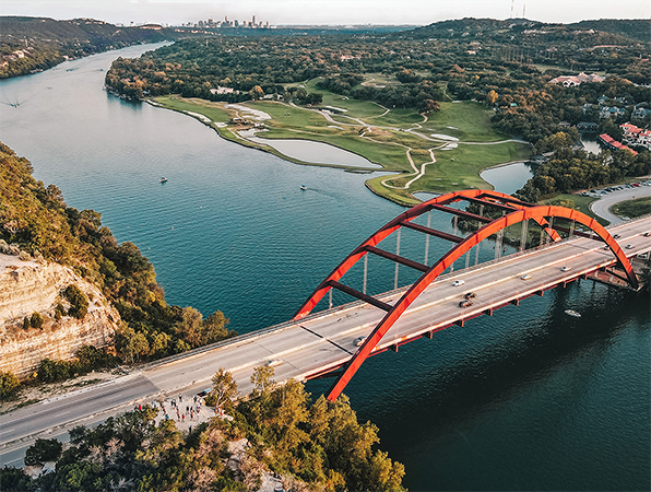 Vue aérienne d’un fleuve et d’un pont à Austin, au Texas, avec la ville en arrière-plan.