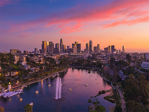 Vue aérienne des gratte-ciel de Los Angeles, avec un parc et un lac au premier plan.