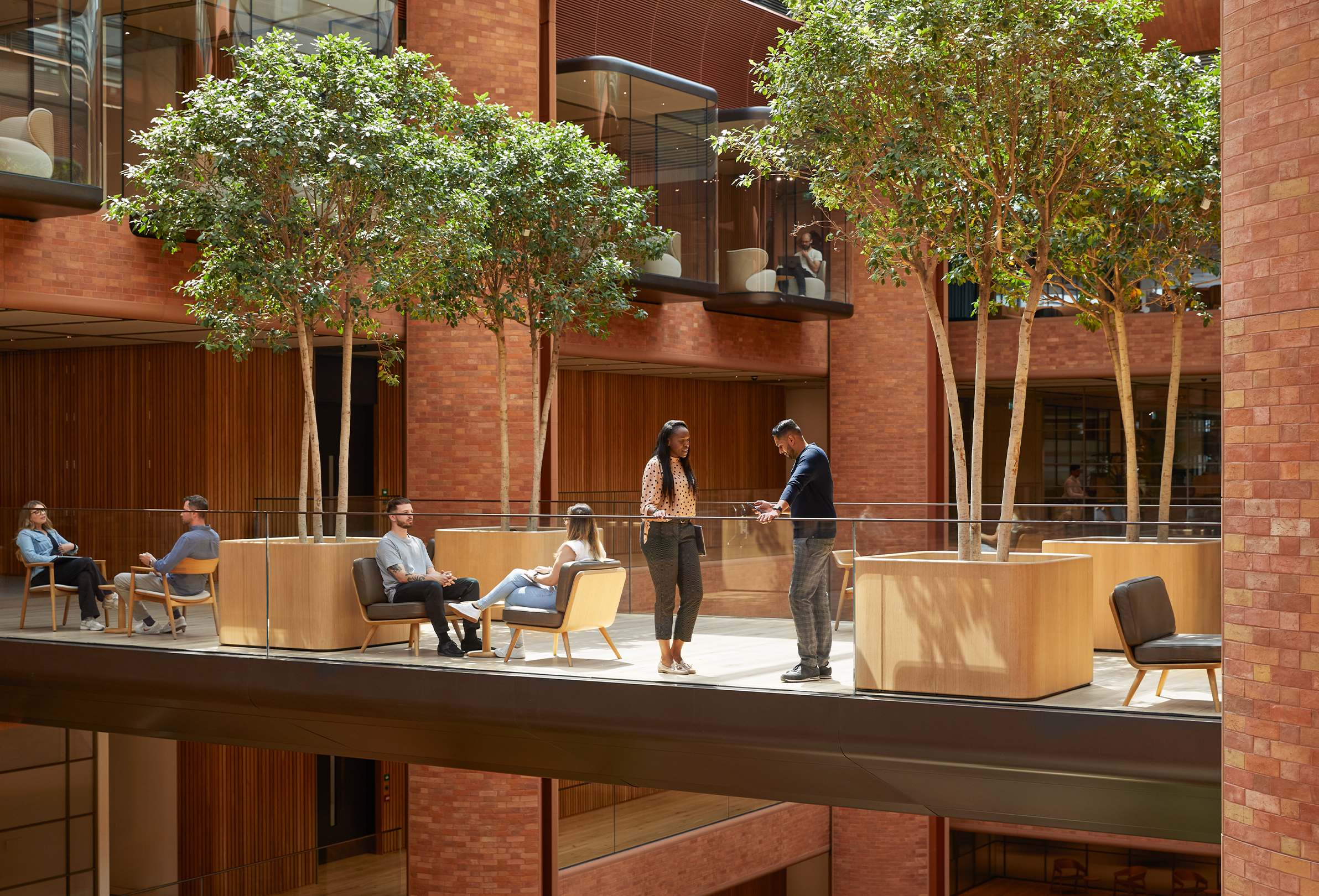 Varias personas del equipo de Apple reunidas en diferentes conversaciones en el atrio de Battersea.