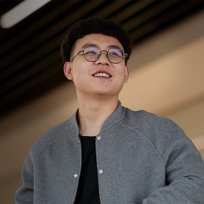 Jason 站在室內，笑著望向右邊。