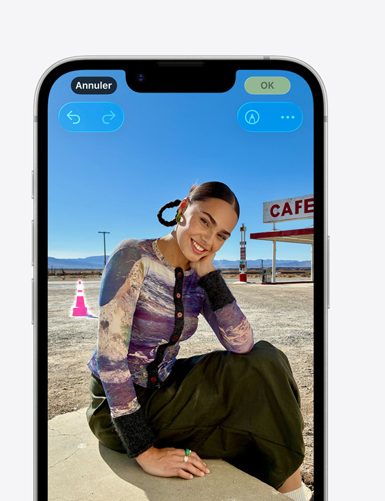 Écran d’un iPhone, photo d’une personne souriant sur la plage, montrant comment supprimer un cône en arrière-plan avec l’outil Correction