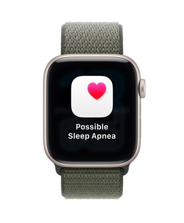 Apple Watch SE 3，採用星光色鋁金屬錶殼，展示疑似睡眠窒息症通知及白色盒子內的粉紅色心形圖案，機身右側設有數碼錶冠，配搭森林色運動手環