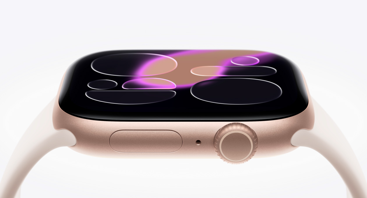Apple Watch Series 11, cassa in alluminio color oro rosa, lato destro, display in vetro rinforzato Ion-X sospeso sopra all’orologio, Digital Crown, microfono, tasto laterale, sensore convesso nella parte inferiore, cinturino Sport rosa fard