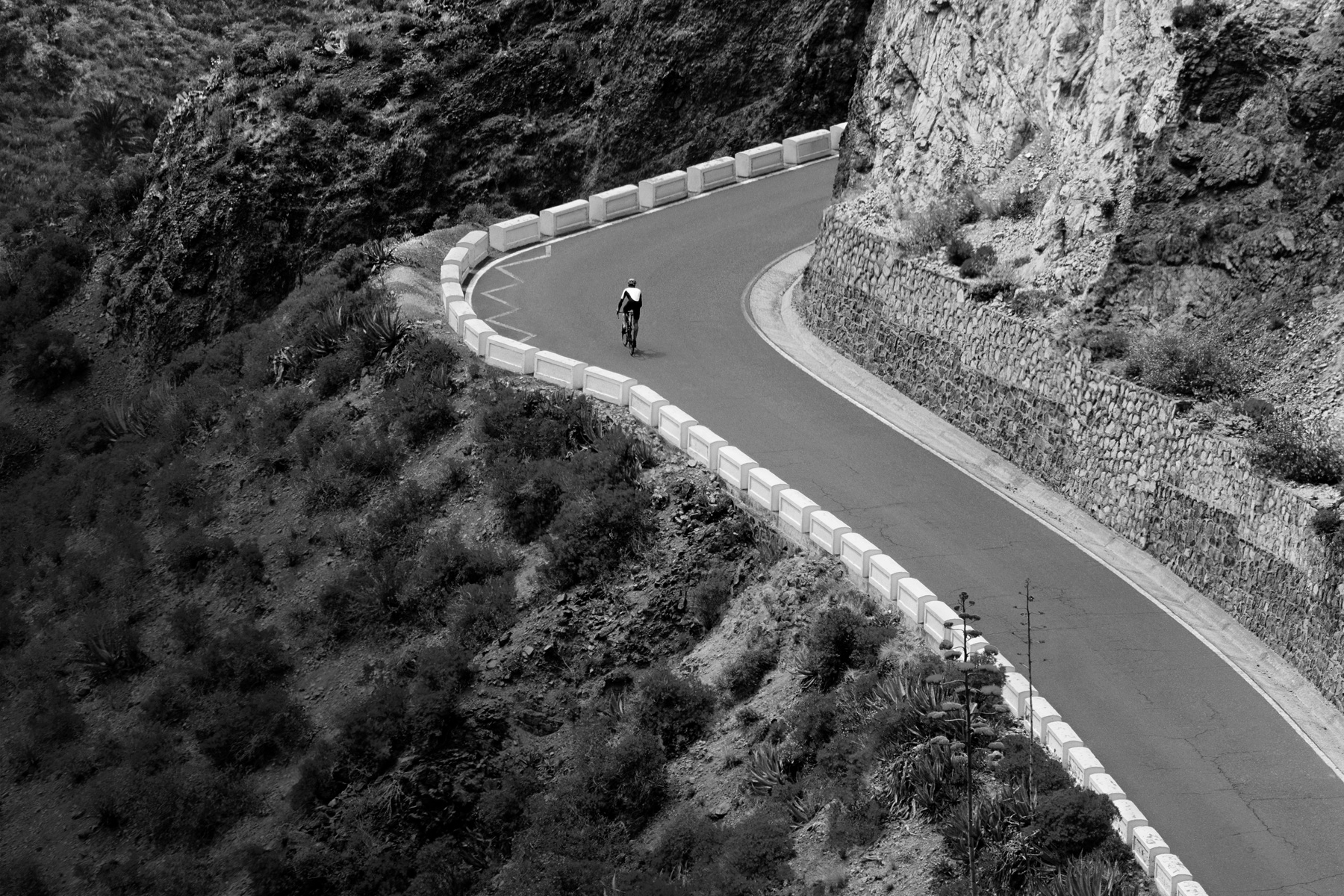 Una persona che va in bici su una strada di montagna
