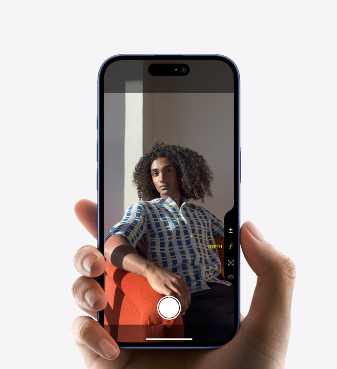 Palec tiskne prvek Ovládání fotoaparátu na boku iPhonu 16 Pro k nastavení hloubky ostrosti.