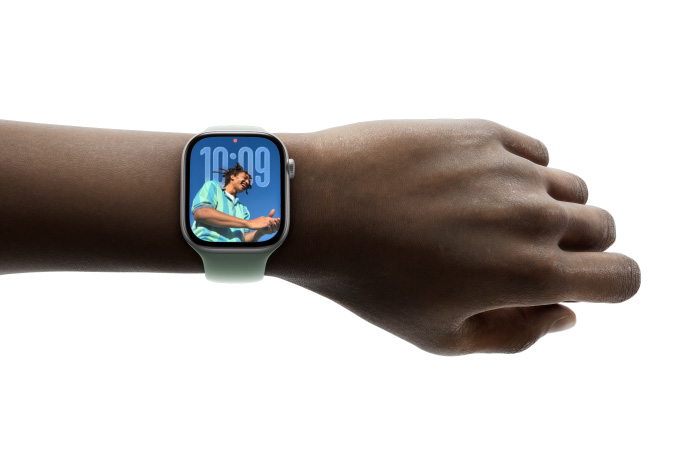 Apple Watch in Silber mit Gummiarmband am Handgelenk einer Person, Zifferblatt zeigt Notizen App und eine Nachricht