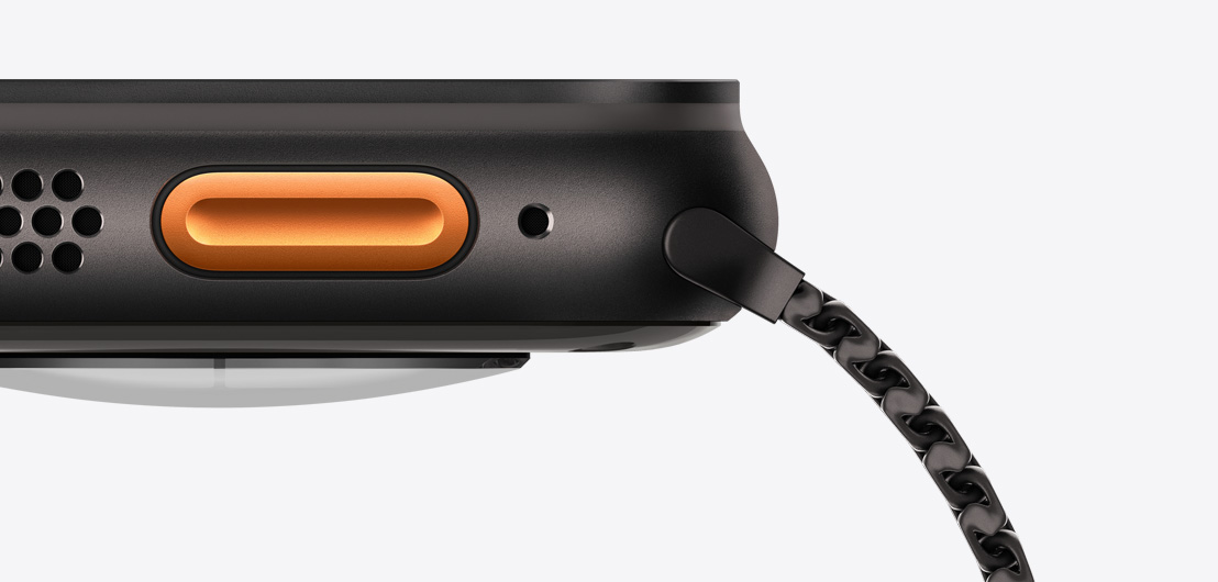 Apple Watch Ultra 3 med urkasse av svart titan. På venstre side vises høyttaleren og lufteventilen, Handlingsknappen og mikrofonen.
