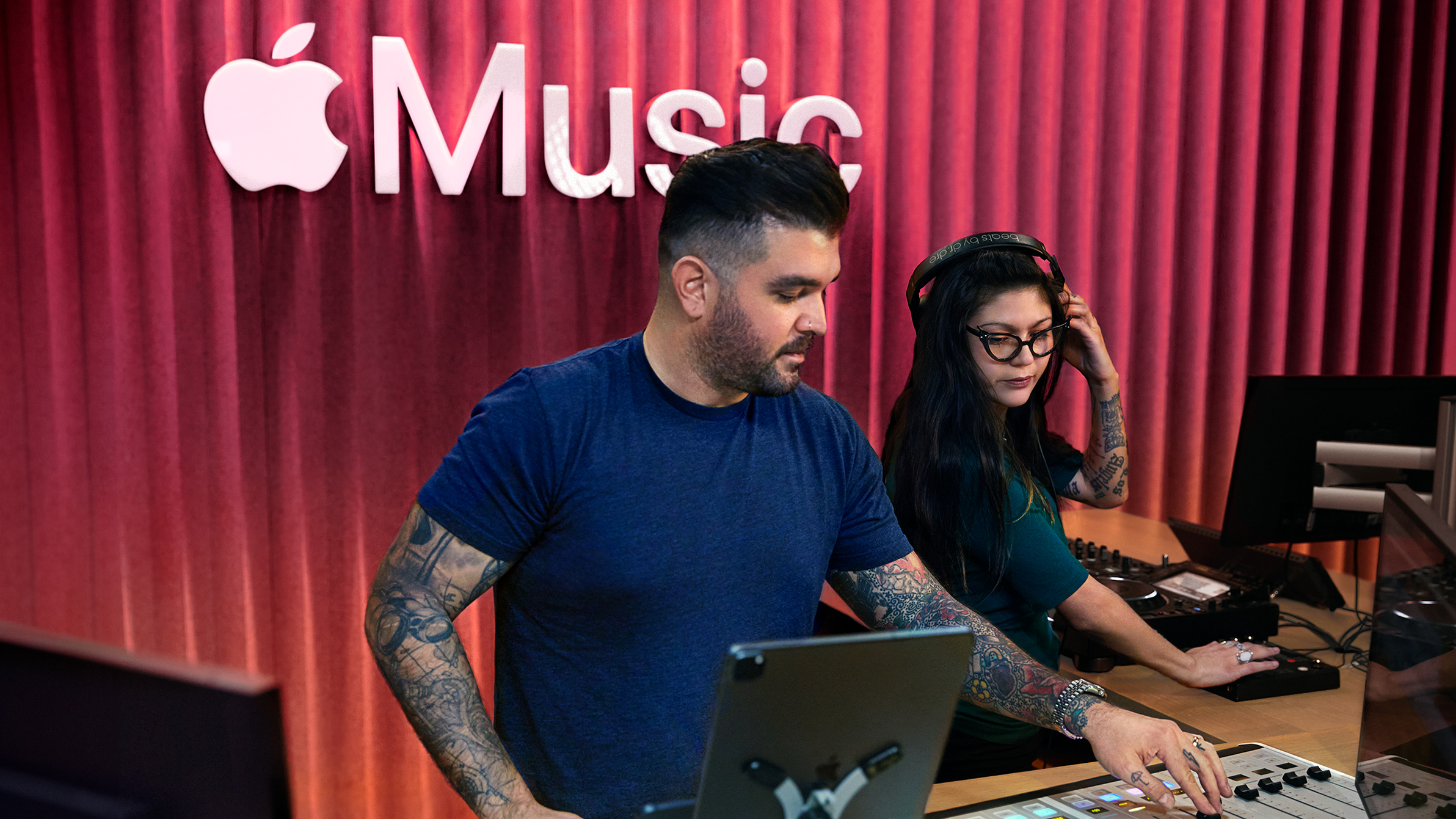 To Apple-medarbeidere bruker et miksebord i ett av Apple Musics lydstudioer.