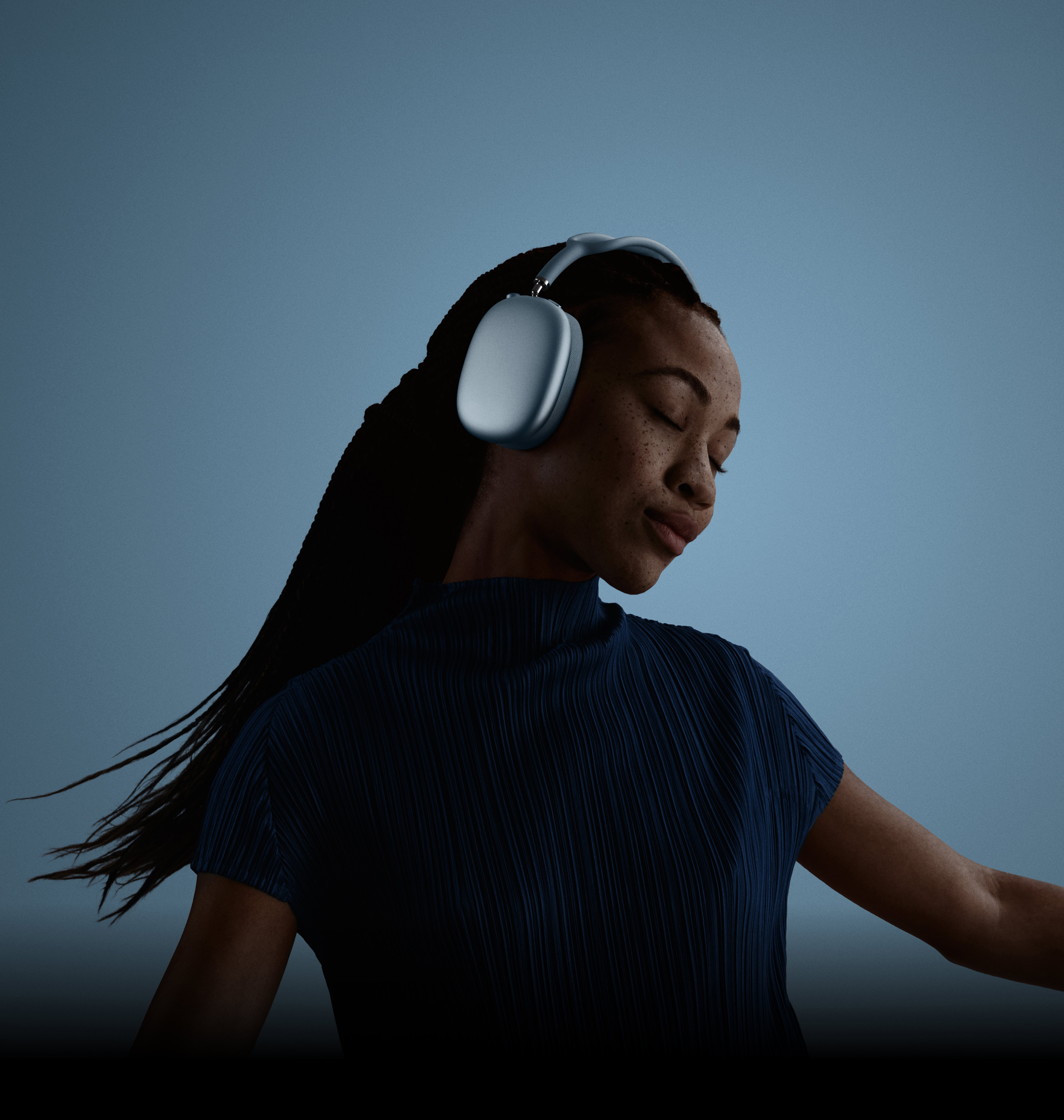En kvinne med lukkede øyne som lener hodet mot venstre og har på seg AirPods Max.