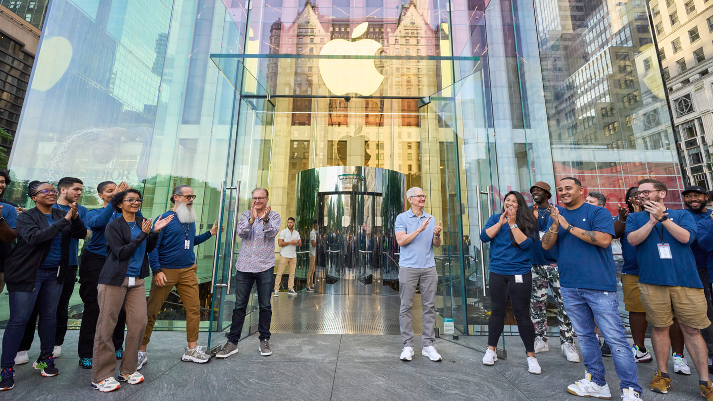 Greg Joswiak và Tim Cook chào đón khách hàng vào cửa hàng.
