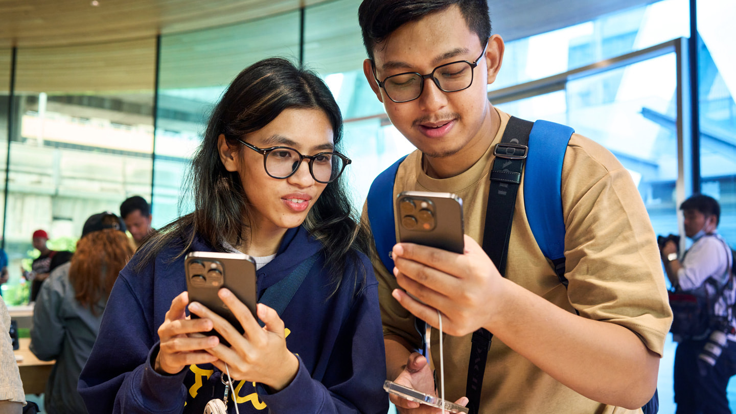 Khách hàng đang dùng thử iPhone 15 Pro Max (ảnh trái) và iPhone 15 Pro (ảnh phải).