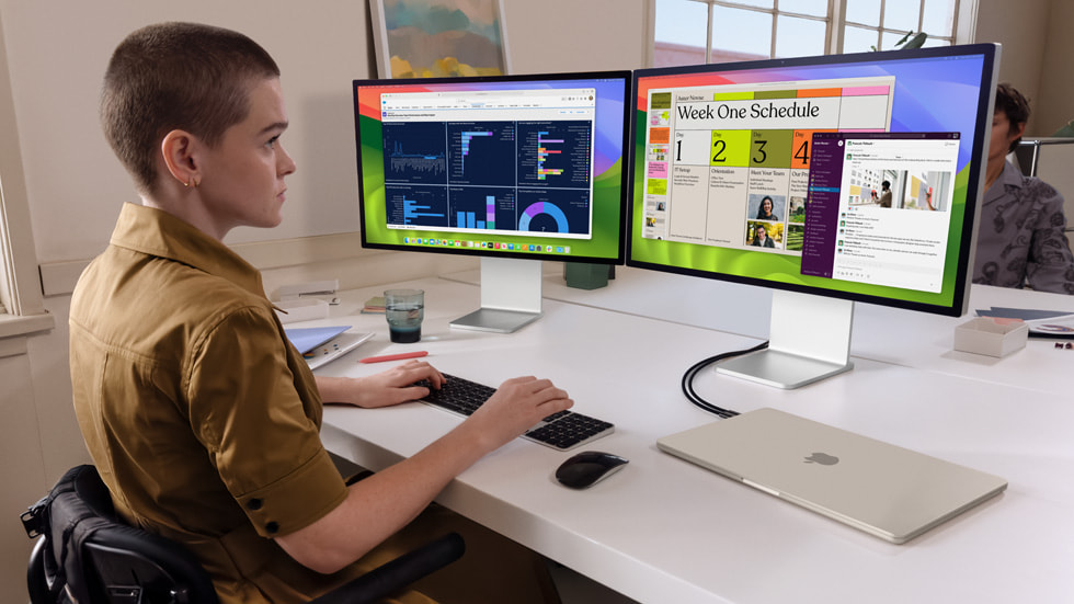 En person jobber på nye MacBook Air koblet til to eksterne skjermer.