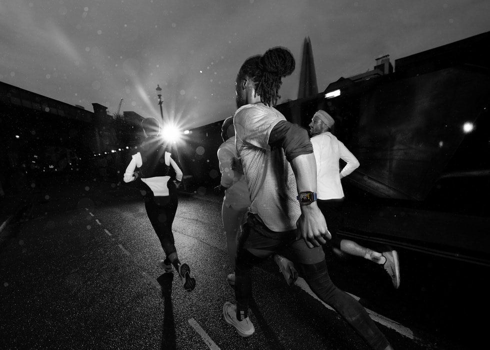 Des personnes courant dans la nuit portent l’Apple Watch Ultra 2. 