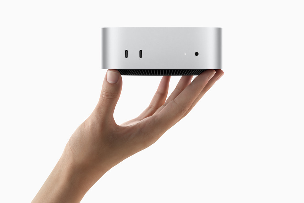 Une main tenant le nouveau Mac mini.