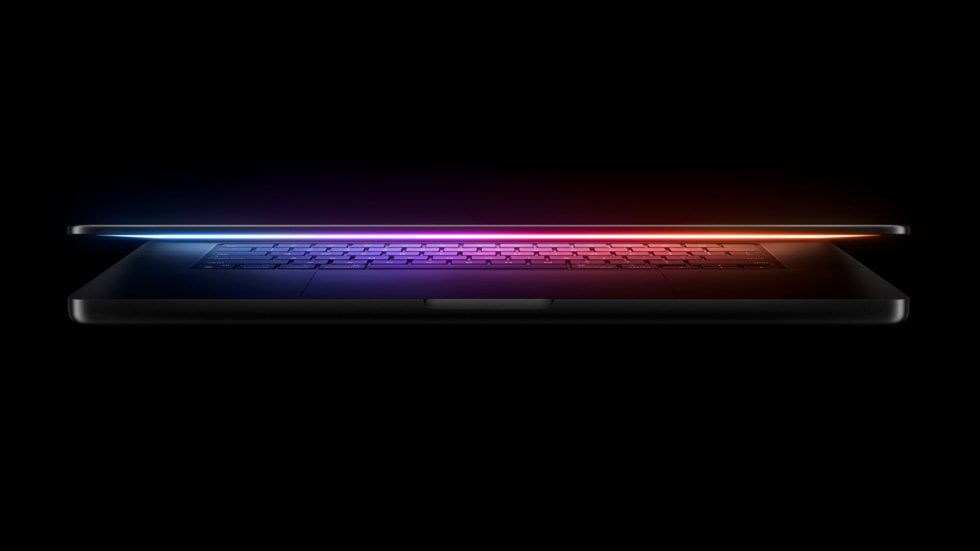 En nästan stängd MacBook Pro ger ifrån sig ett mångfärgat ljussken.