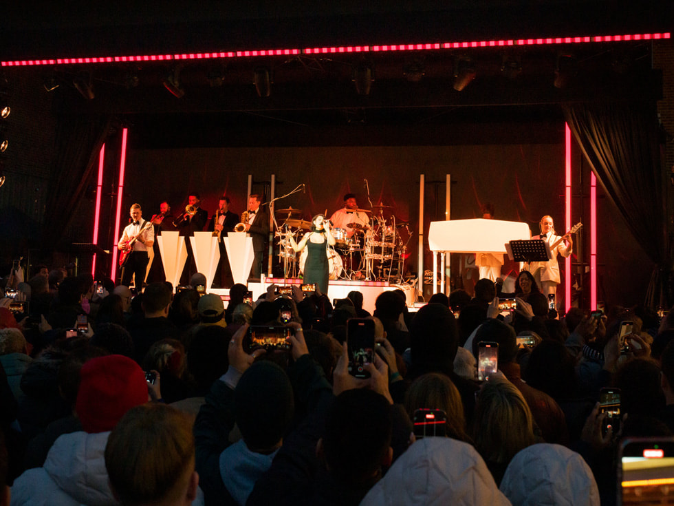 La musicienne britannique primée RAYE donnant un concert festif devant la communauté locale.