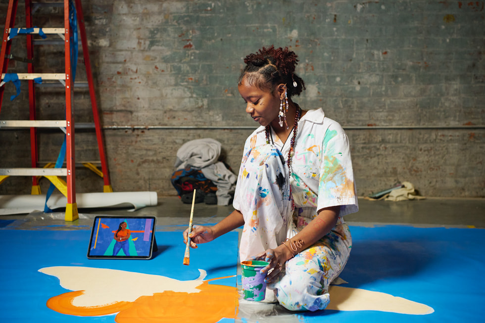 Une jeune artiste peint un papillon sur la nouvelle murale de l’Arts New Orleans.