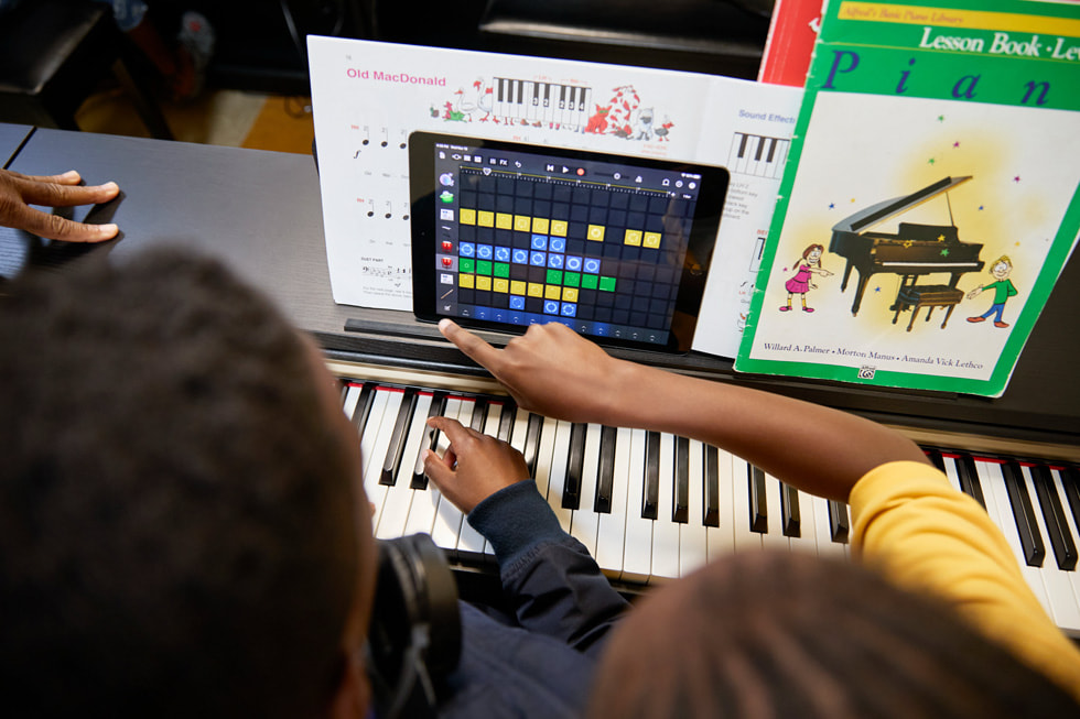 Des élèves travaillent avec un iPad à leur piano pendant une leçon de piano au Ellis Marsalis Center.