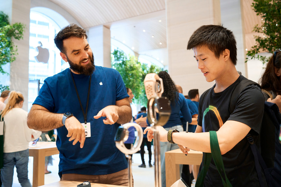 Członek zespołu obsługuje klienta przy stole wystawowym z zegarkami Apple Watch w sklepie Apple Brompton Road.