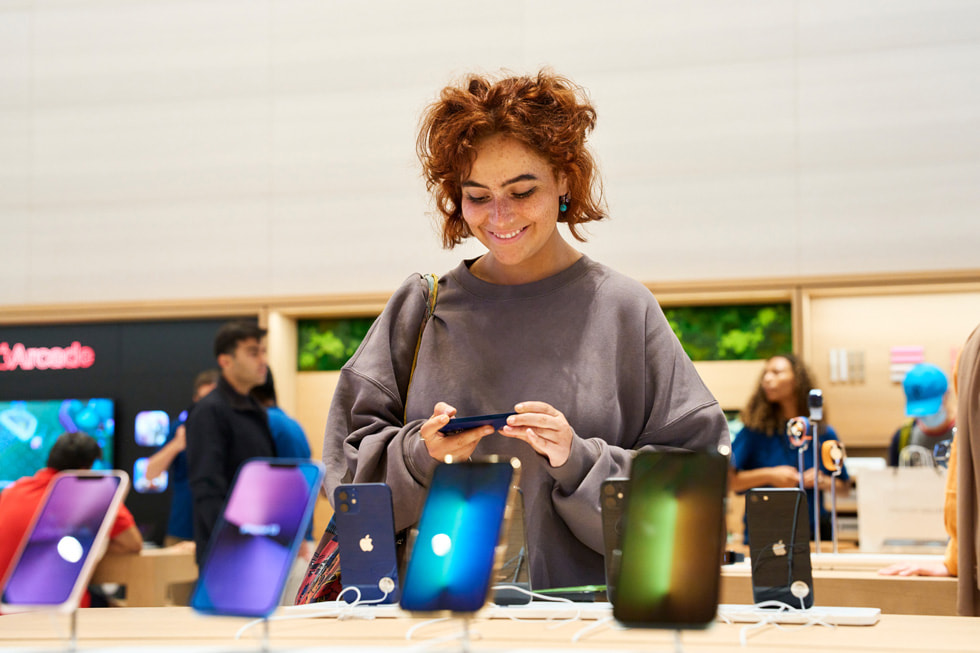 Klientka ogląda linię iPhone’ów w sklepie Apple Brompton Road.