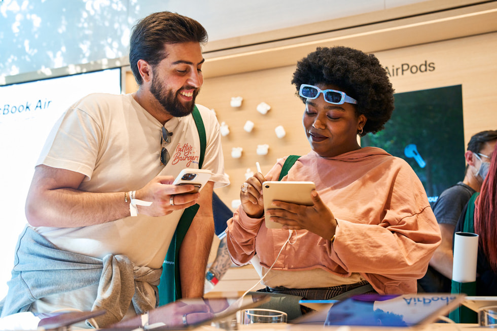 Klientka testuje Apple Pencil i iPada mini w sklepie Apple Brompton Road, a inna osoba obserwuje efekty jej testów.