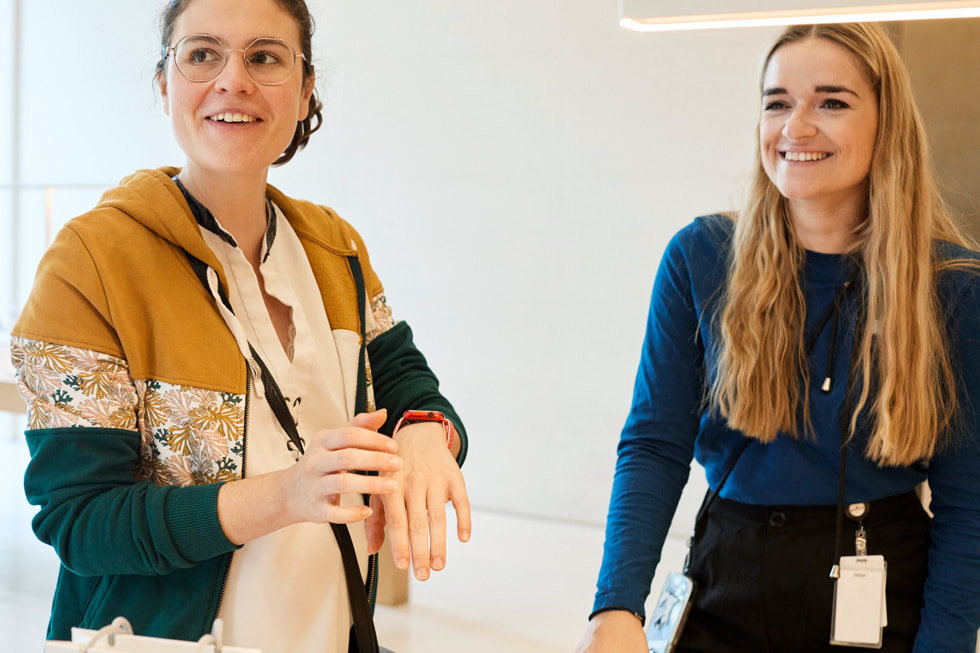 En kunde med en Apple Watch sammenligner enheten sin med Apple Watch-utstillingsmodellen i Apple Champs-Élysées.