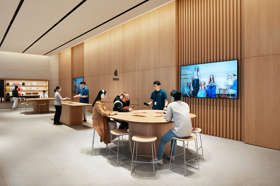 Des clients et l’équipe créative Apple près des stations réservées aux séances Today at Apple à l’intérieur de l’Apple Gangnam.