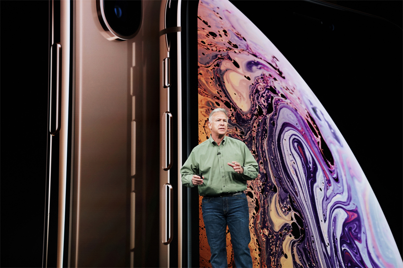 Sahnede iPhone Xs ekranının önünde duran Phil Schiller.