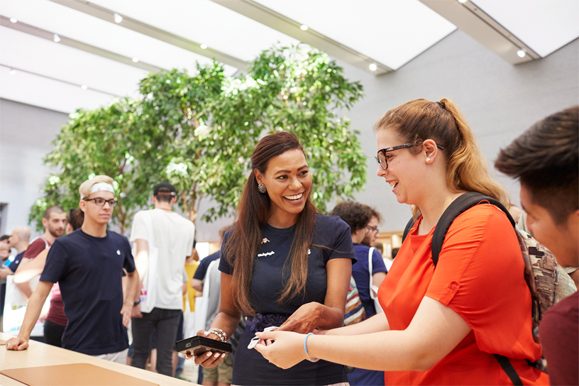 En Apple Piazza Liberty-medarbejder får sig et godt grin sammen med en gæst.
