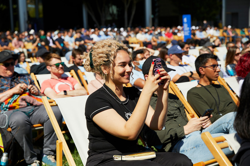 Les participants assistent à la Keynote de la WWDC22 à l’extérieur du Caffè Macs d’Apple Park.