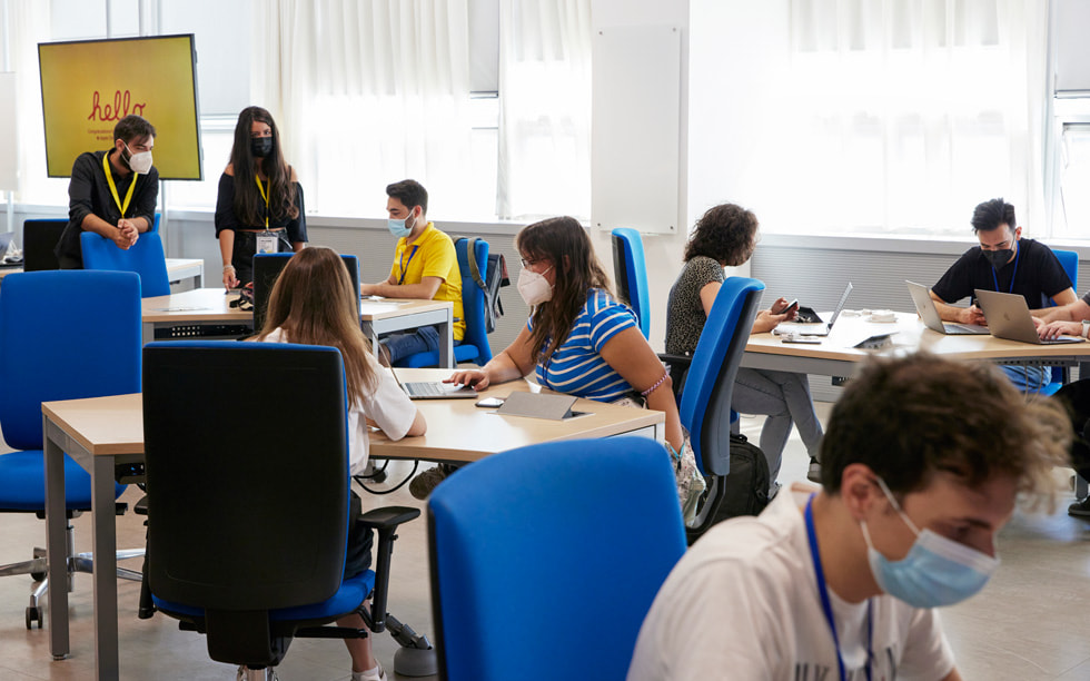 Studenci pracujący przy stołach w siedzibie Developer Academy w Neapolu.