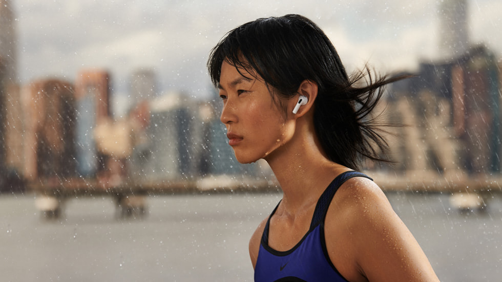 빗속에서 AirPods(3세대)을 착용하고 있는 여성.