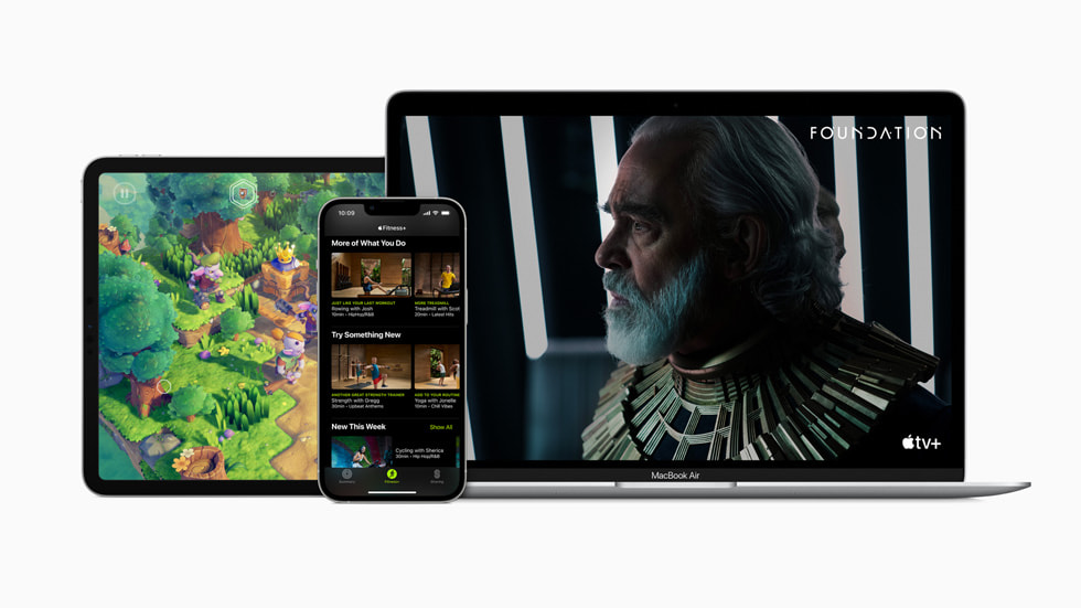Apple Arcade på iPad Pro, Apple Fitness+ på iPhone 13 Pro og Apple TV+ på MacBook Air.