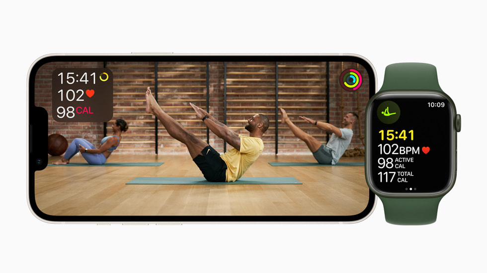 Fitness+ 필라테스 세션을 보여주는 가로 방향 iPhone 화면과 그 옆에 놓인 Apple Watch Series 7.