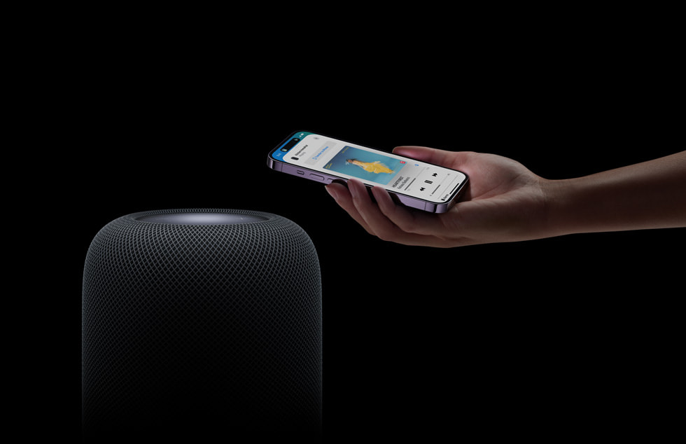 Een gebruiker die een iPhone boven een HomePod (2e generatie) houdt.