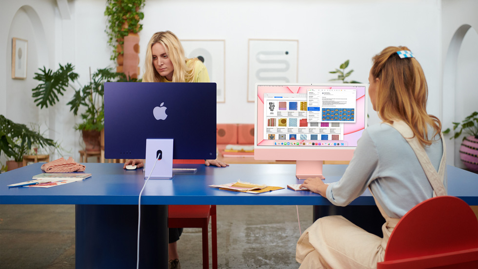 İki kadın ortak çalışma alanında iMac’lerini kullanıyor.