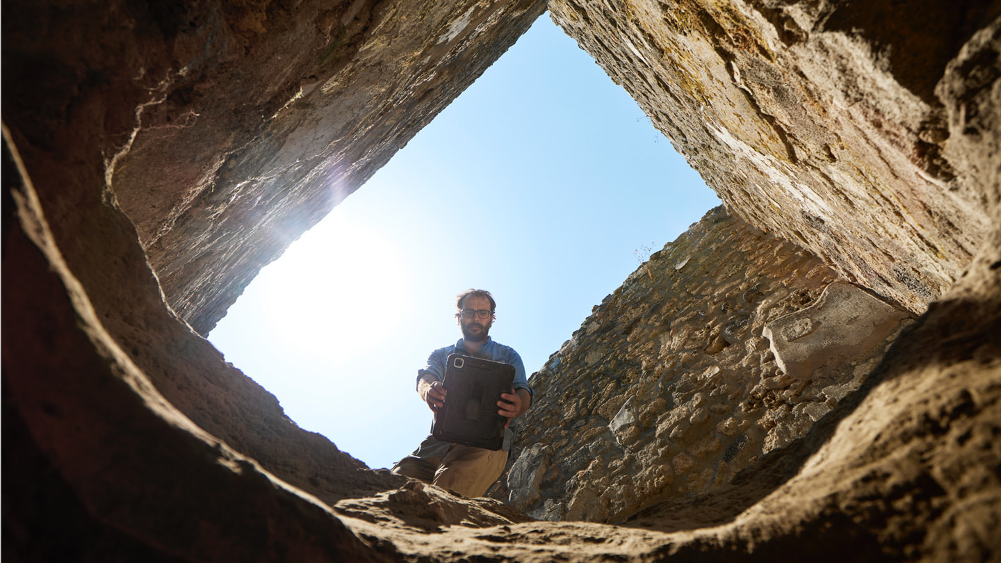 Toma desde el interior de una excavación en la que se ve al Dr. Rogers sosteniendo un iPad Pro sobre la abertura del agujero.