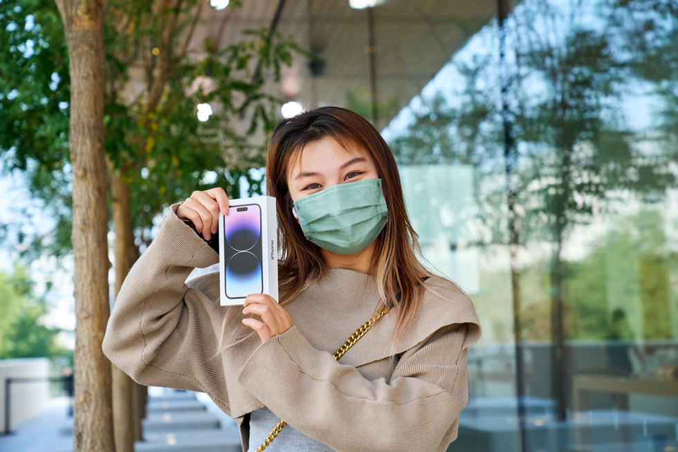 En kunde holder sin nye iPhone 14 Pro utenfor Apple Sanlitun.