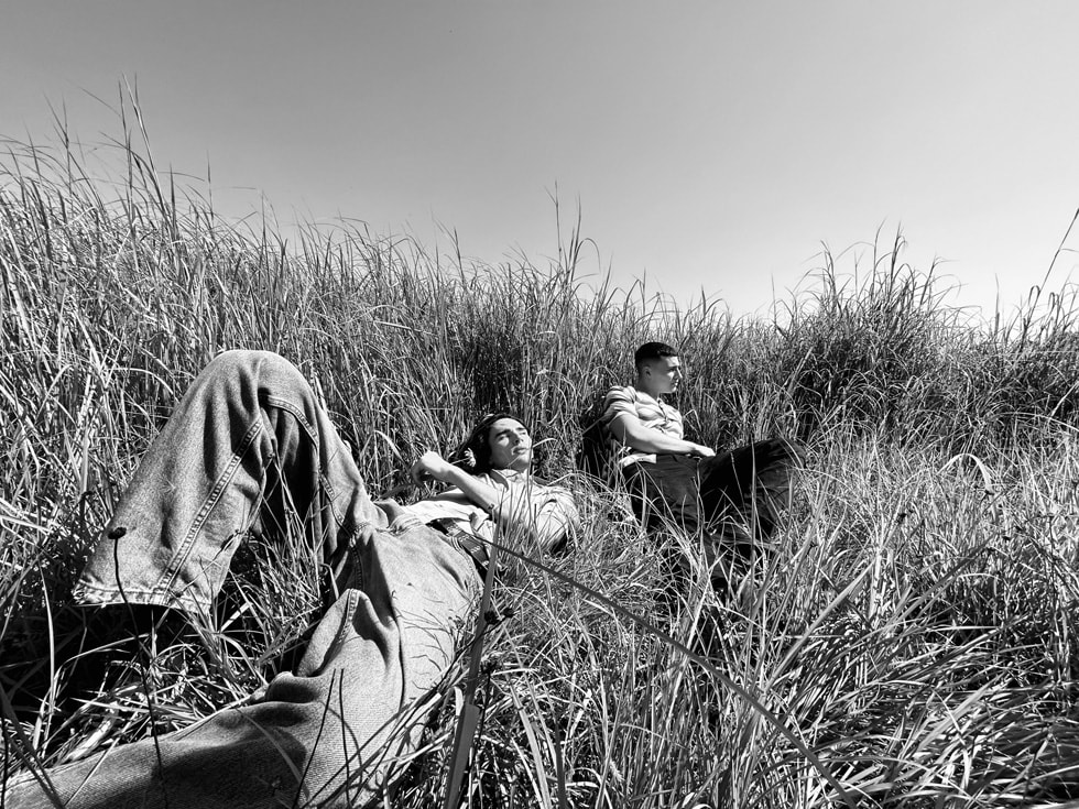 Deux personnes allongées sur une photo en noir et blanc prise dans un champ.
